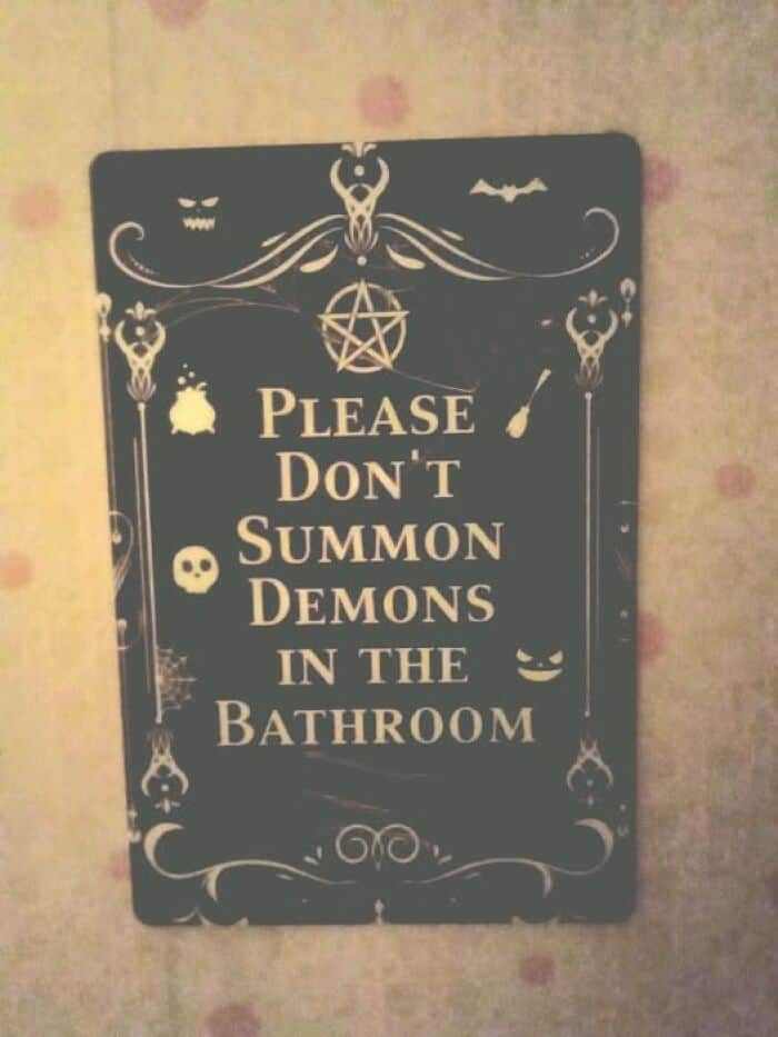A spooky, gothic-themed funny sign for a bathroom asking guests "Please Don't Summon Demons."