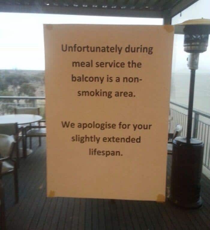 A funny sign on a balcony apologizing to smokers for their "slightly extended lifespan."
