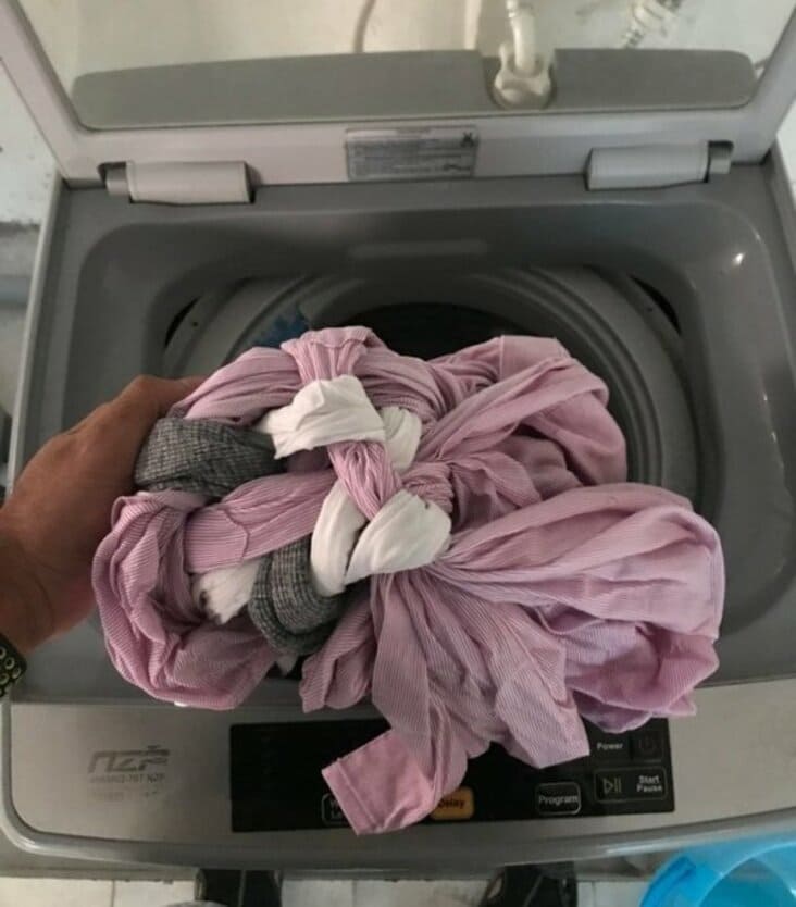 Laundry fail comparing a shrunk sweater to a phone for scale