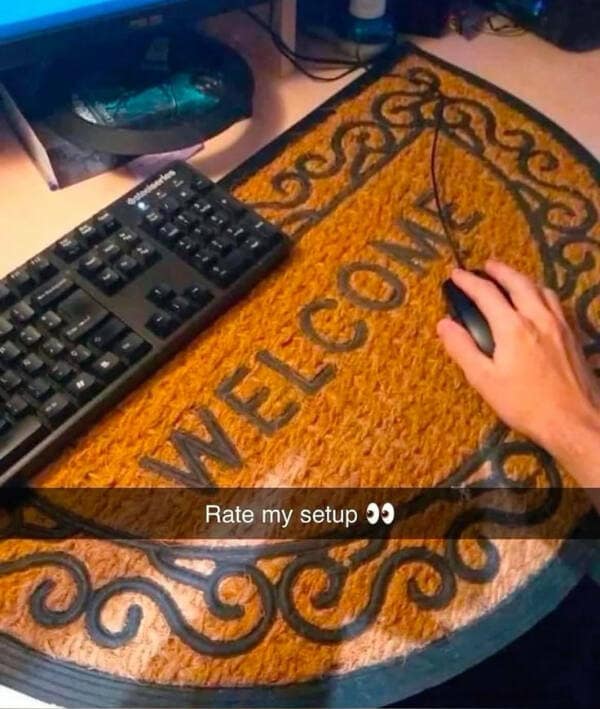 A hilarious meme of a "cursed" gamer setup, "Rate my setup," showing a "Welcome" doormat as a mousepad.