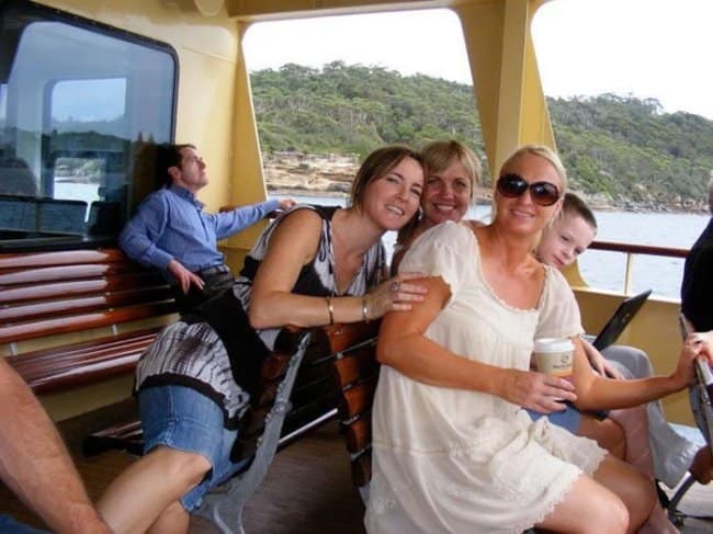 Funny forced perspective optical illusion of a man in the background appearing tiny and sitting on a woman's shoulder