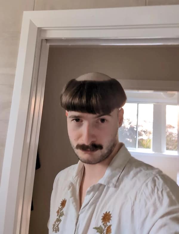 A man with a mustache and a "Friar Tuck" style monk bowl cut, shaved on top.