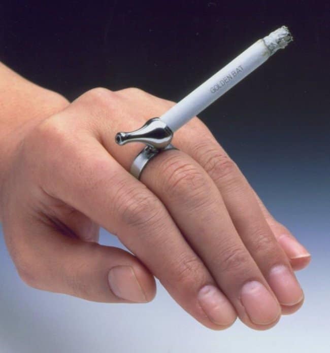 A strange and functional metal ring designed to hold a lit cigarette for hands-free smoking.