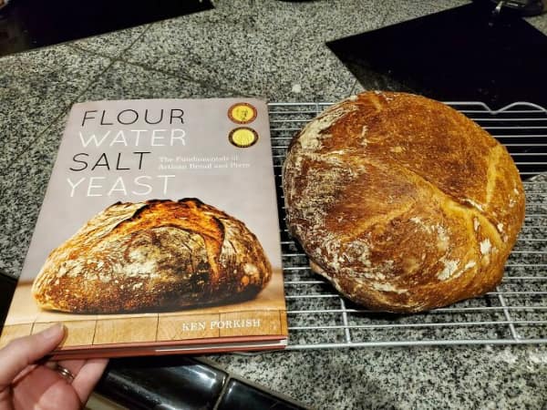 Homemade sourdough bread loaf looking identical to the cookbook cover photo.