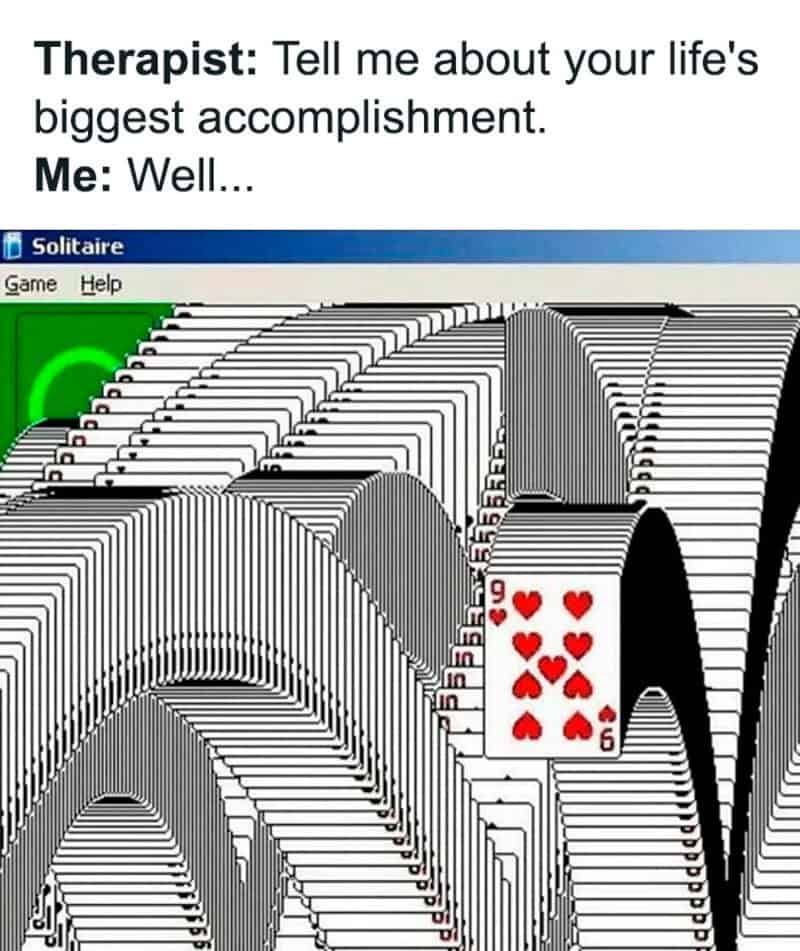 Screen capture of the classic Windows Solitaire winning animation with cascading cards filling the entire green background.