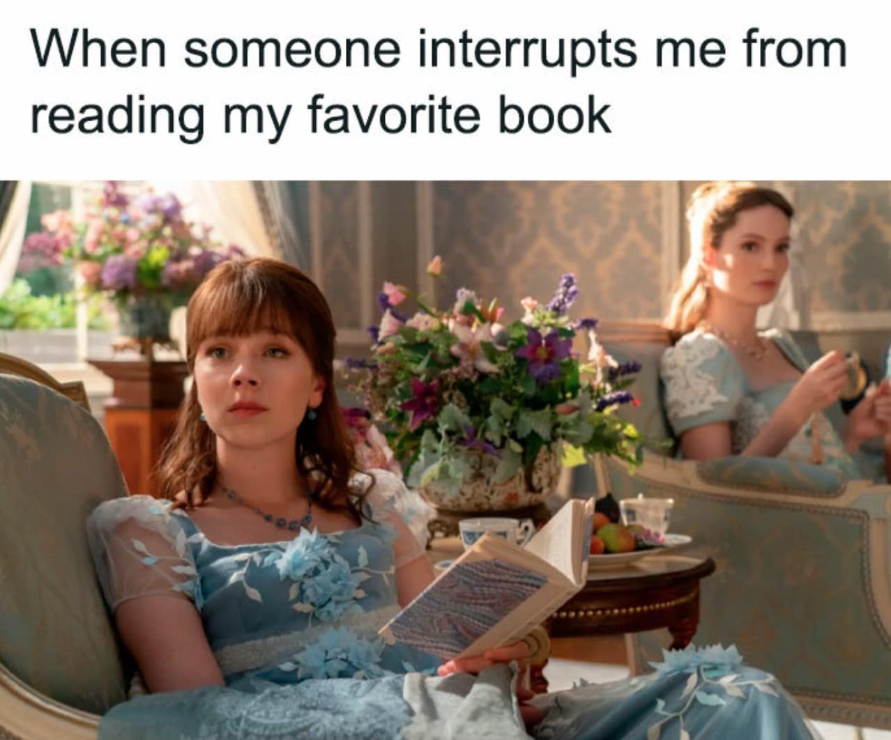 Eloise Bridgerton holding a book and glaring with intense annoyance. The perfect Bridgerton meme for introverts who hate being interrupted while reading a good novel.