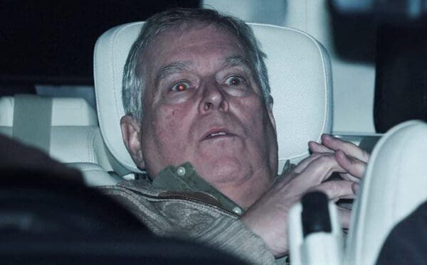 A viral Prince Andrew arrest meme showing a deeply unflattering paparazzi photo of the disgraced Duke of York sitting in the back of a car, looking absolutely terrified with glowing red eyes.