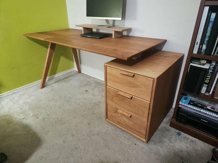 Minimalist modern wooden office desk with a floating top design and matching three drawer filing cabinet.
