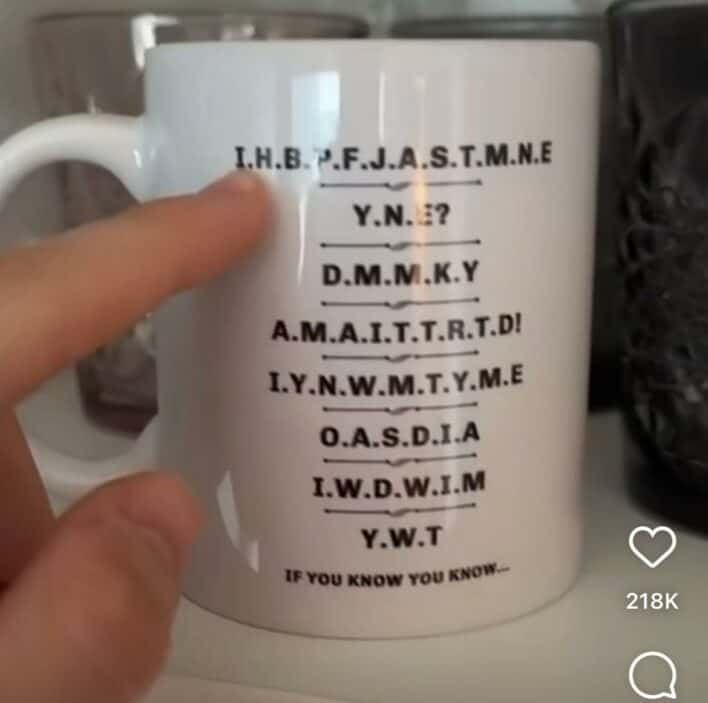 White coffee mug featuring a long string of capital letters and "If you know you know" text.