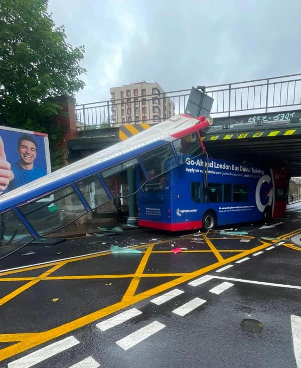 driving fail: A blue double-decker bus with the entire upper deck sheared off and destroyed after striking a low-clearance railway bridge