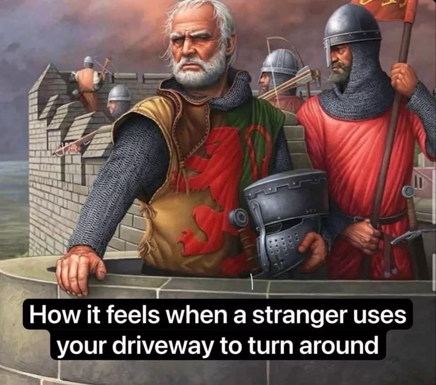 A classic meme depicting medieval soldiers on a castle wall intensely watching below, captioned as how it feels when a stranger uses your driveway to turn around.
