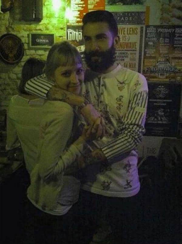 Couple hugging in a bar where their similar shirts create a confusing bodily illusion.