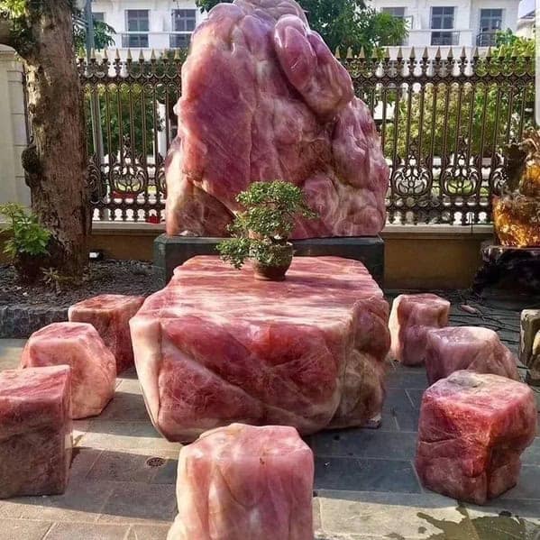 A set of cursed furniture carved from stone to resemble giant slabs of raw, marbled red meat, creating a visceral and unappetizing dining experience.