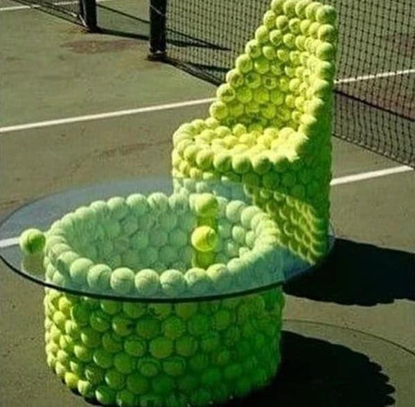 A cursed furniture patio set where a chair and table are completely covered in hundreds of fuzzy yellow tennis balls.