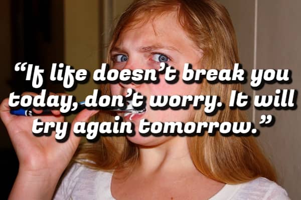 A young girl brushing her teeth with a demotivational quote about life trying to break you again tomorrow.