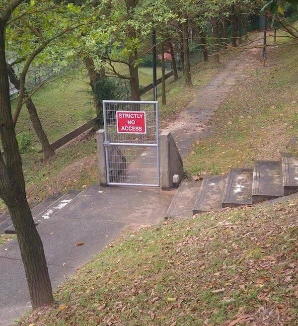 A "Strictly No Access" gate standing alone on a path with no connecting fence.