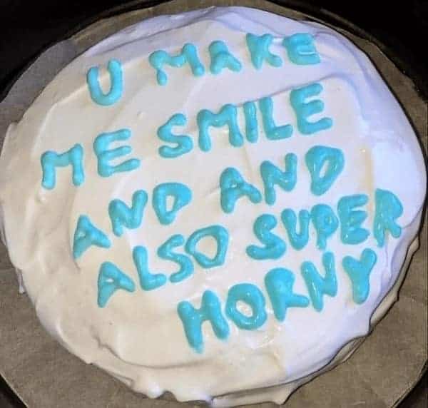 A romantic but blunt funny cake with blue icing telling the recipient they make the giver smile and also super horny.