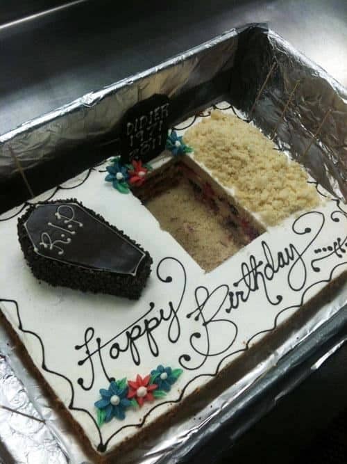 A cake fail involving a funeral-themed birthday cake where someone has scooped a massive square out of the center, ruining the design.