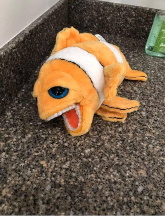 Orange clownfish plush toy mimicking Nemo but horrifyingly manufactured with human teeth. A truly cursed toy design.