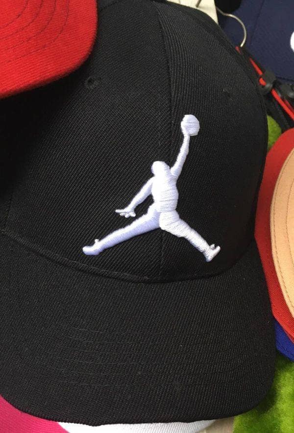 Black baseball cap featuring a badly stitched bootleg Air Jordan logo with a misshapen body. Hilarious fake apparel.