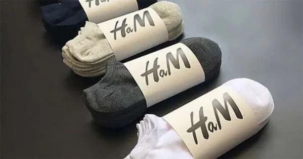 Rolled pairs of ankle socks wrapped in a paper label reading HaM mimicking the iconic clothing brand logo.