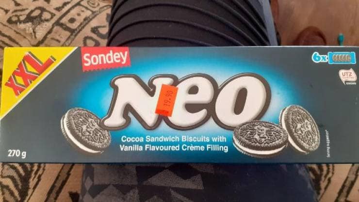Box of Neo cookies looking exactly like Oreos. Shopper holding a cheap grocery store brand rip off of the classic treat.