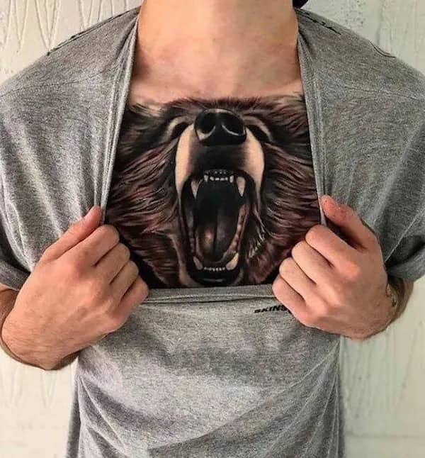 Creative tattoo of a roaring bear positioned so the mouth opens when the person pulls their shirt.