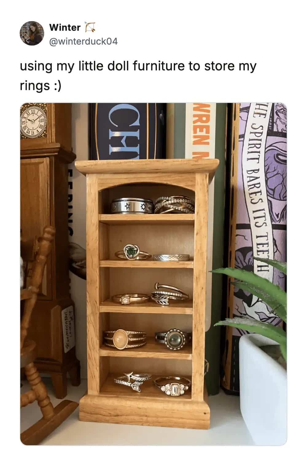 Creative use of miniature dollhouse furniture as a tiered display shelf for various jewelry rings.