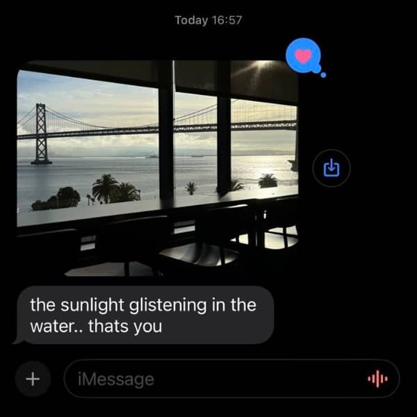 Romantic iMessage screenshot showing a sunset over a bridge with a sweet glistening water compliment for the recipient.