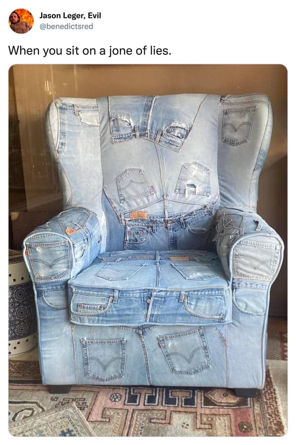 Wingback armchair upholstered in a patchwork of light blue denim jeans with visible back pockets and labels.