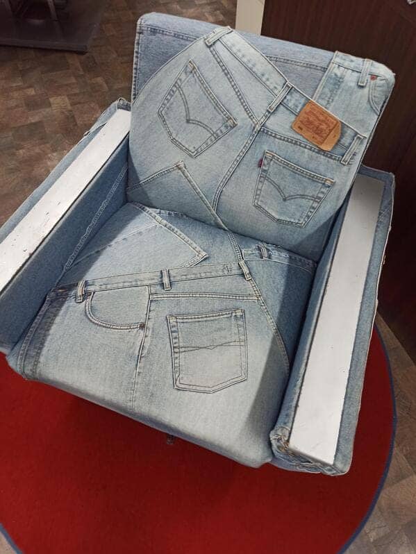 Overhead view of a denim armchair featuring several back pockets and waistbands as part of the upholstery.