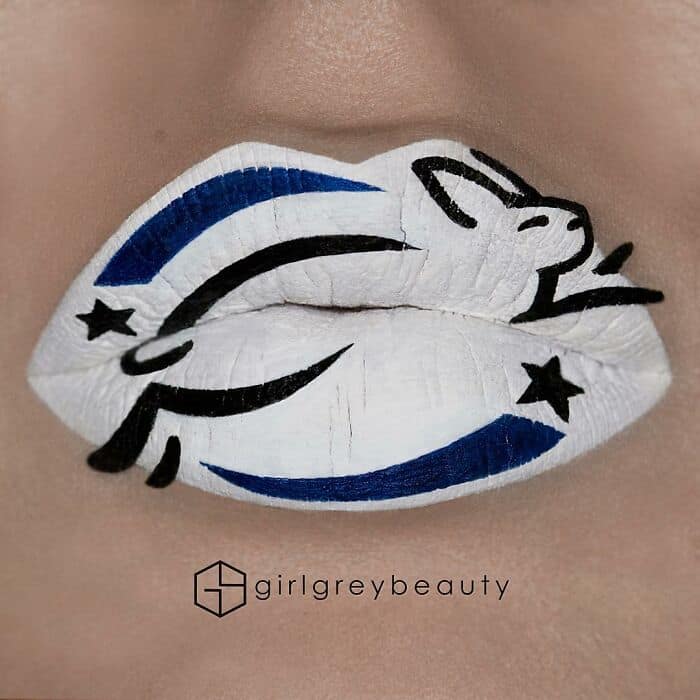 A sleek, graphic amazing lip art design featuring a dynamic black and blue leaping rabbit over a stark white background, showcasing the bold, illustrative style of Andrea Reed lip art.