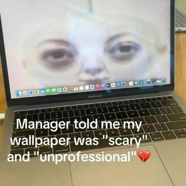 A workplace hilarious meme showing a laptop with a terrifying, distorted face as the wallpaper, captioned that the manager called it "scary" and "unprofessional."