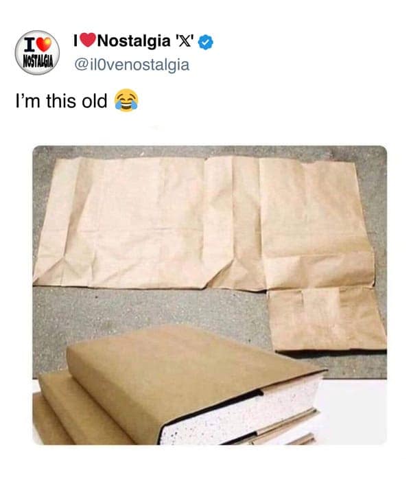 A relatable nostalgic photo showing a brown paper grocery bag being expertly folded to create a custom protective cover for school textbooks, captioned "I'm this old."