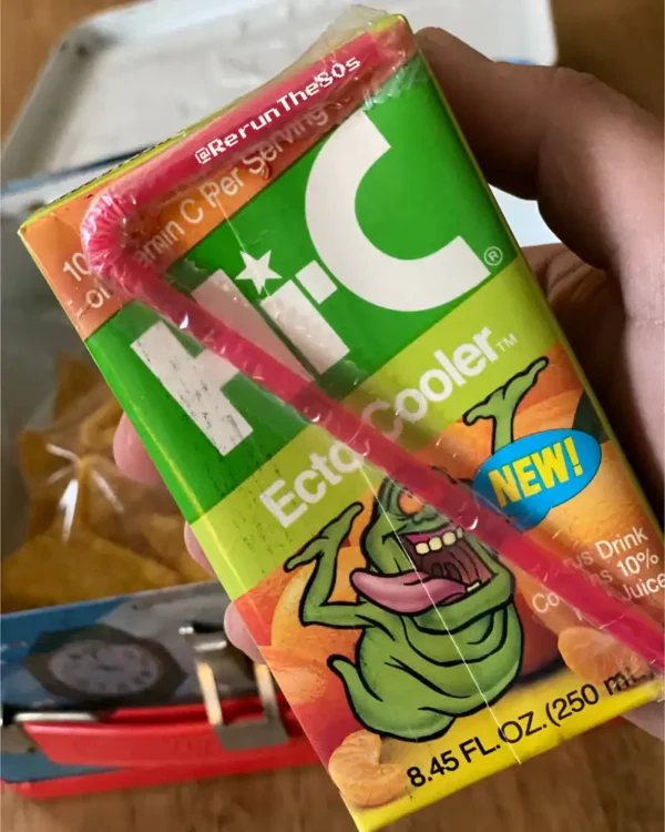 A nostalgic drink favorite, the Hi-C Ecto Cooler juice box featuring Slimer from Ghostbusters holding an orange.