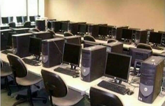 Early 2000s computer lab filled with bulky grey desktop monitors and black tower towers.