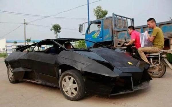 A redneck DIY sports car built from scrap metal painted black, attempting to look like a luxury vehicle.