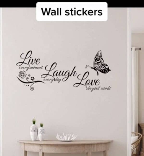 A wall sticker with a butterfly and the phrase "Live every moment, Laugh every day, Love beyond words."