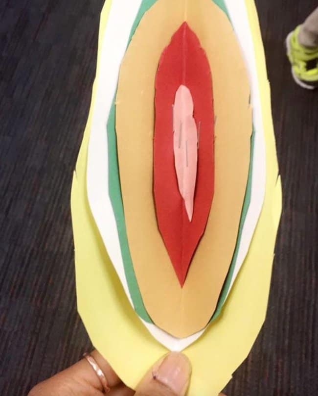 An unfortunate design featuring a layered paper craft with folded red, pink, and yellow paper that looks unmistakably and accidentally nsfw rather than the innocent flower or seed it was likely intended to be.