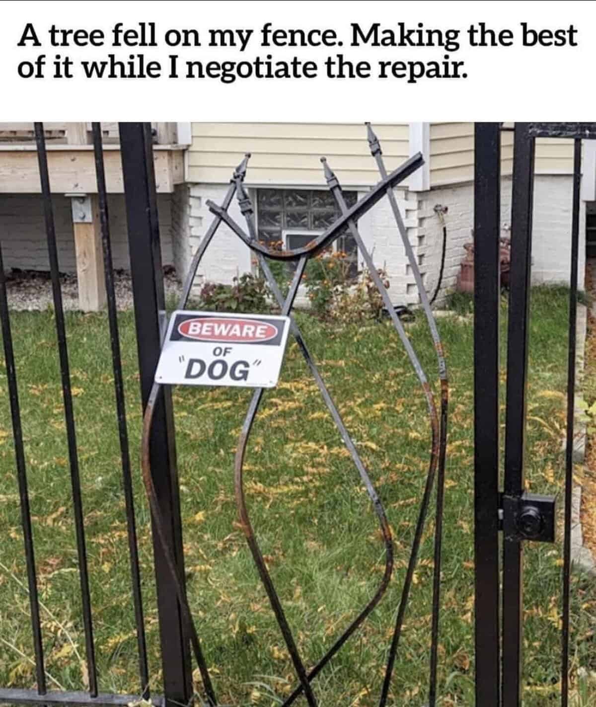 Wrought iron fence bent into an oval shape with a sign reading Beware of Dog.