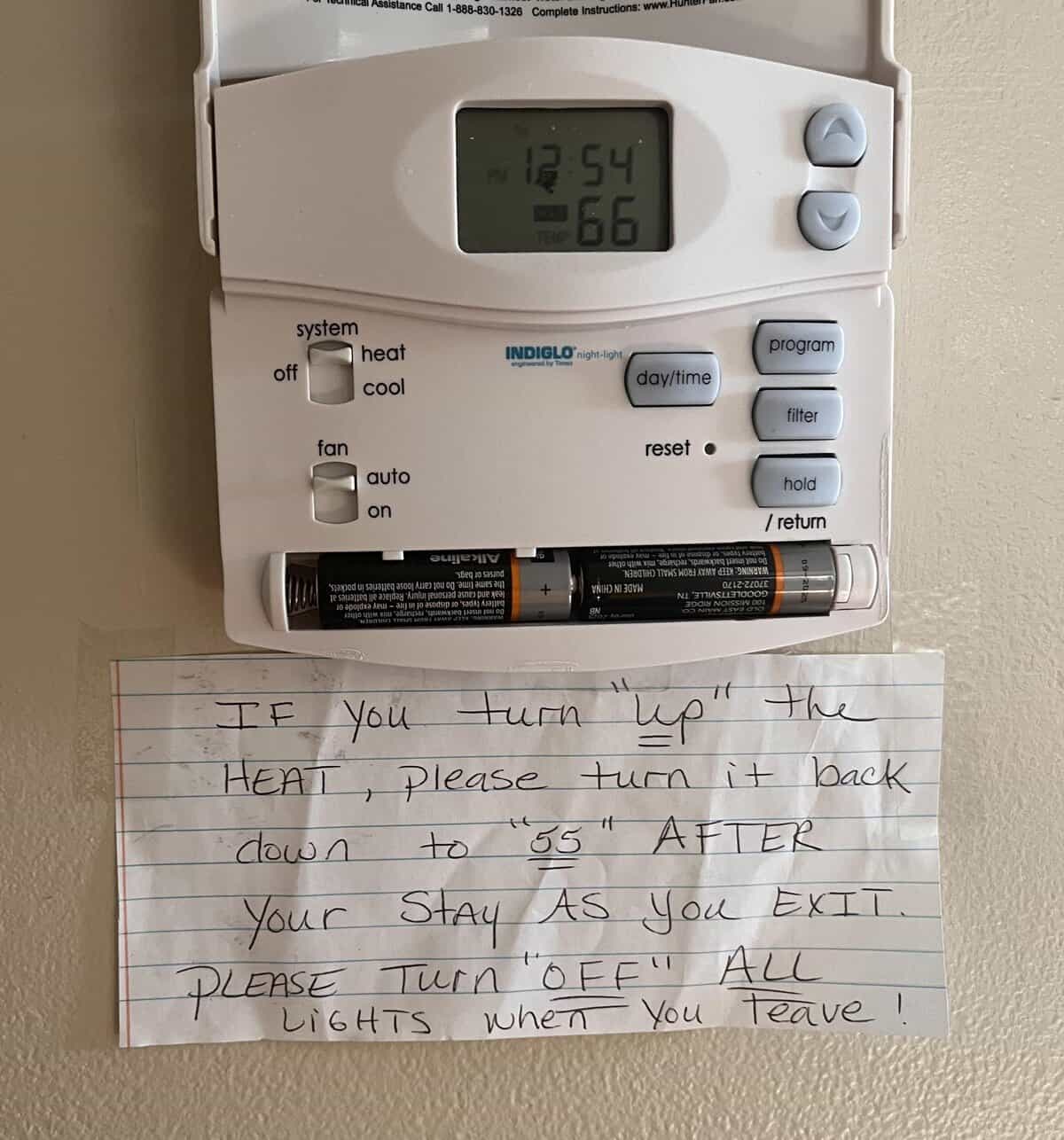 Handwritten note on a thermostat with the words up, fifty-five, and off in quotation marks.