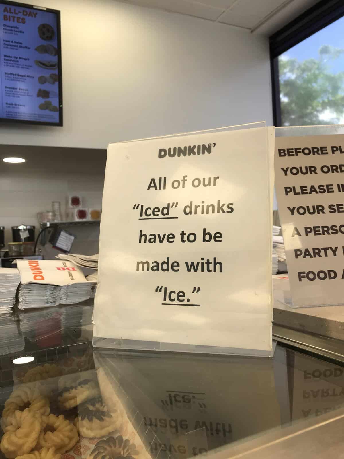 Dunkin' Donuts sign explaining that iced drinks and ice must use quotation marks.
