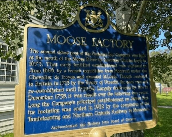 Blue historical plaque for Moose Factory Ontario explaining the Hudson's Bay Company trading post history.