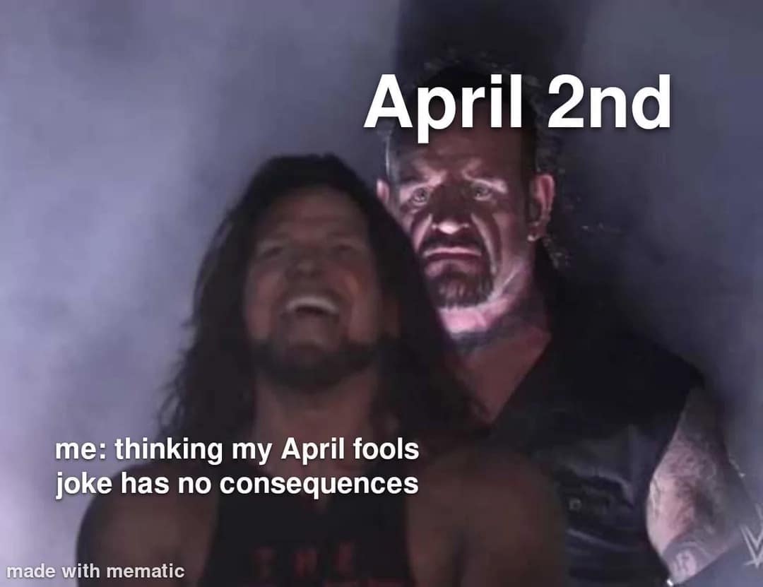 A 2026 April Fools meme using the "Undertaker standing behind AJ Styles" template. AJ Styles is seen laughing and is labeled "me: thinking my April fools joke has no consequences." Behind him, a menacing Undertaker is labeled "April 2nd."