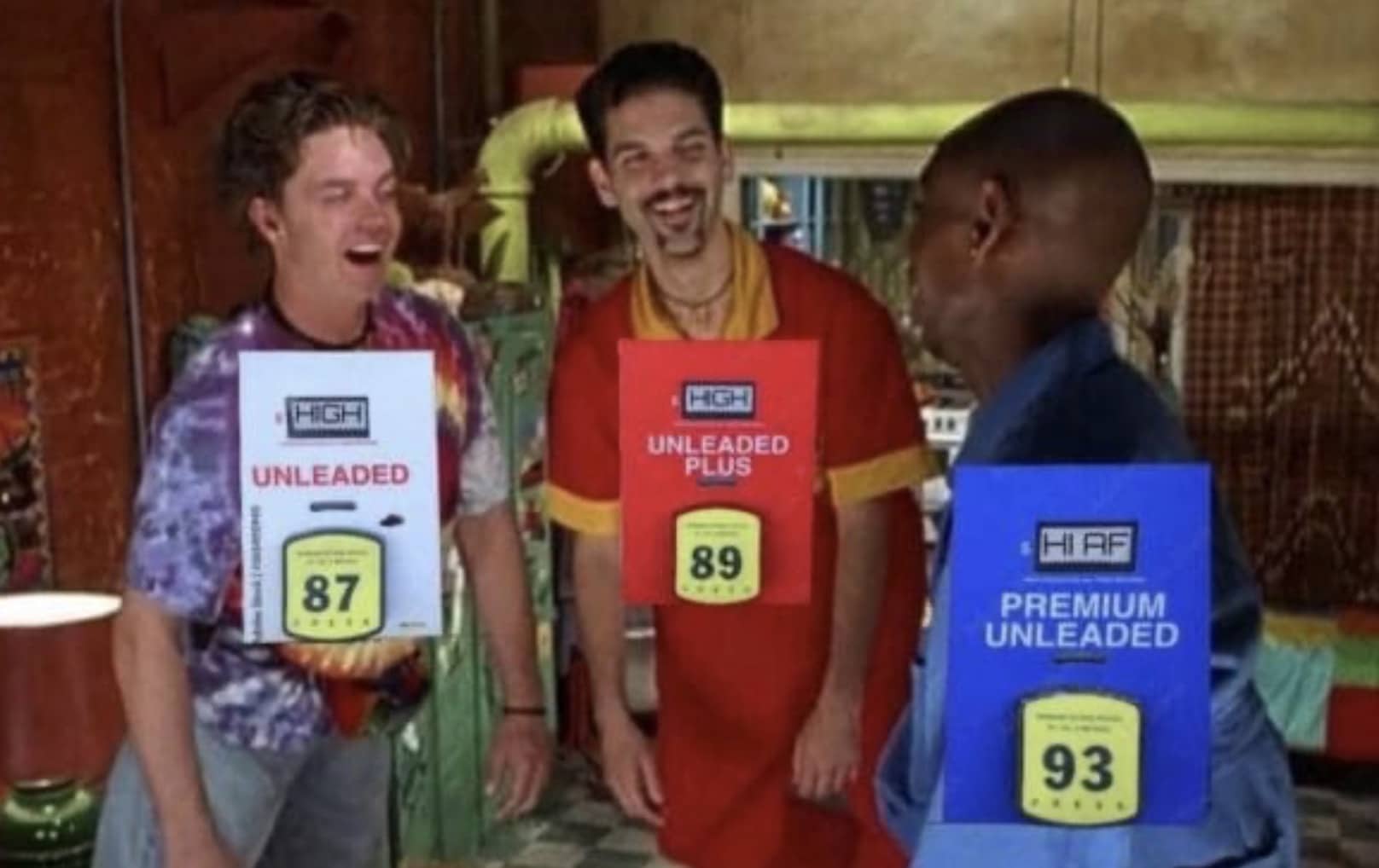 Three men wearing gas pump octane rating signs as funny unleaded and premium fuel costumes.