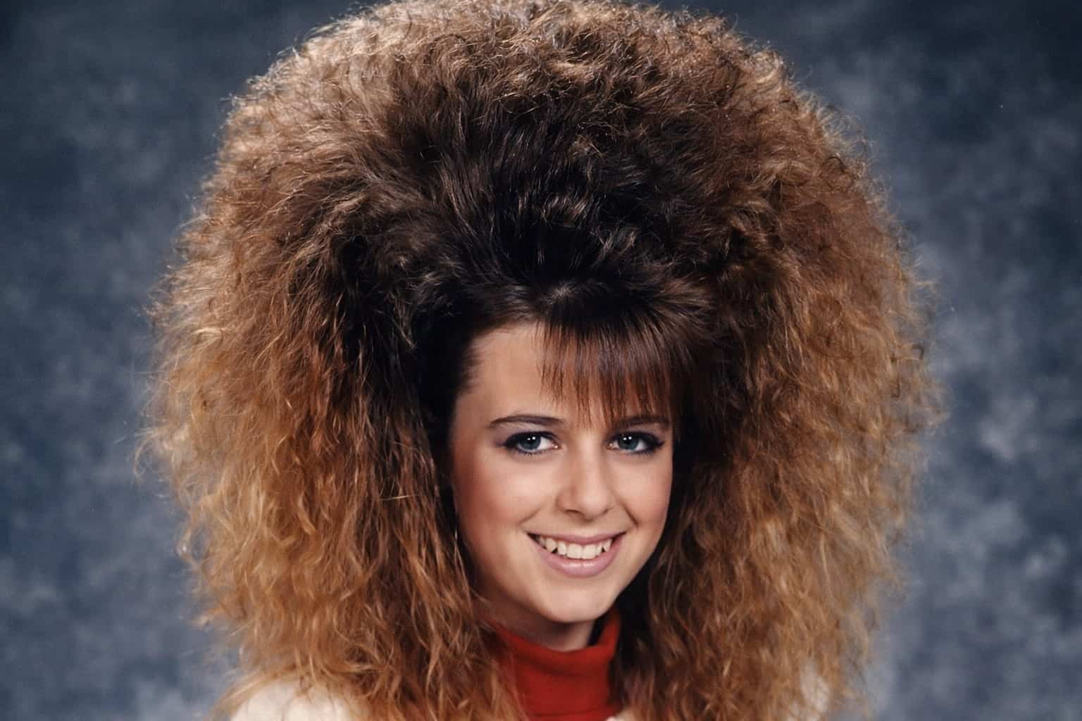Woman with extremely voluminous teased hair, representing crazy 80s hairstyles and vintage fashion humor.