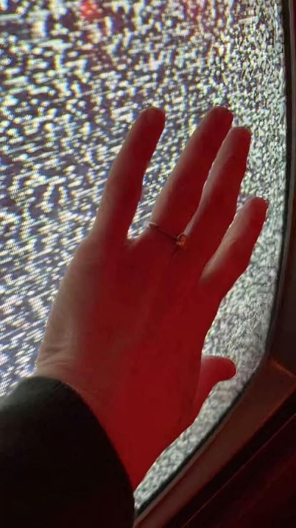 A deeply sensory 90s meme showing a hand pressed against a snowy static CRT television screen, instantly bringing back the 90s nostalgia of feeling the crackling static electricity on your fingertips.