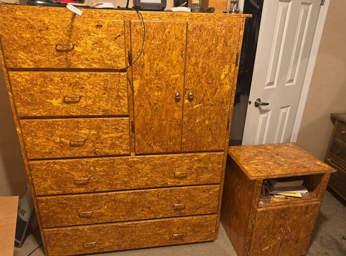 A large bedroom dresser and nightstand painted to look exactly like cheap OSB particle board. A visually offensive hilariously bad DIY upcycling attempt.