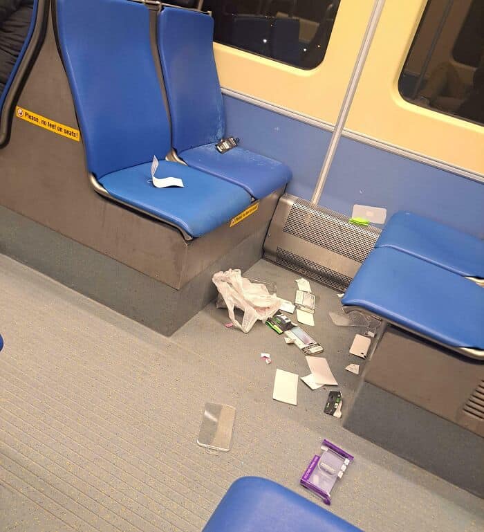 An overwhelming mess of paper scraps, plastic bags, and trash litters the floor of a subway car, showcasing the blatant disrespect often shown by annoying people on public transit