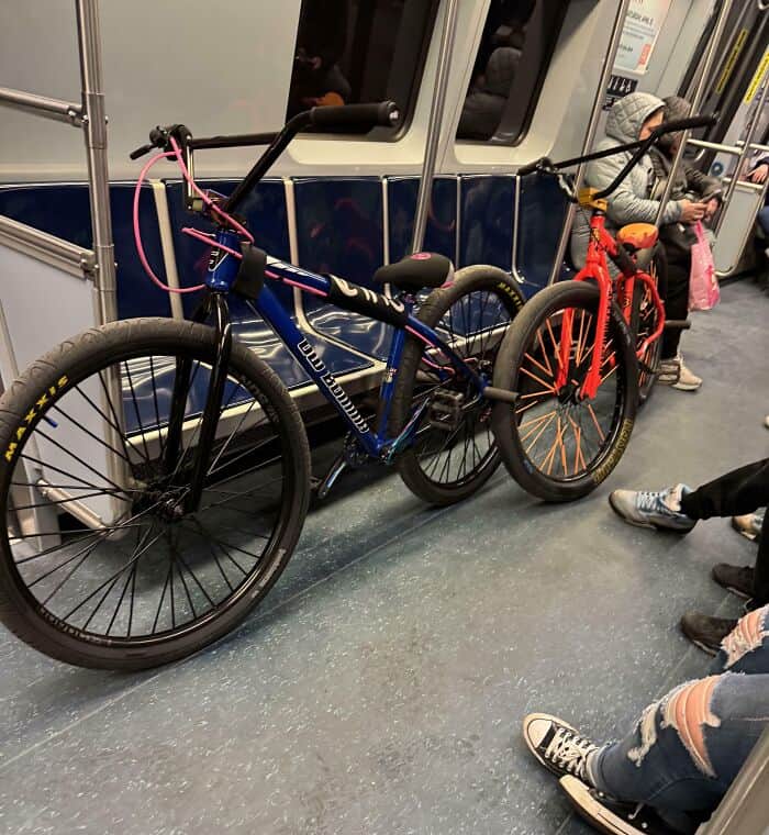 Two BMX bikes lean across an entire row of train seats, leaving no room for other standing passengers in this textbook example of annoying people on public transit